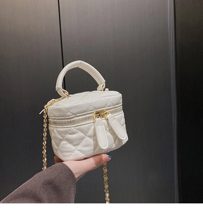Close-up of a white mini vanity case with quilted diamond pattern and gold chain strap