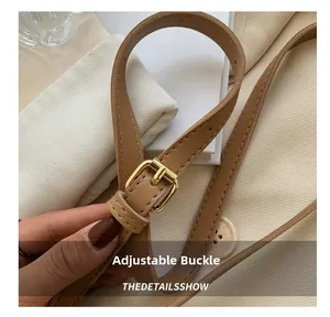 Close-up of brown leather strap with adjustable golden metal buckle and fine stitching