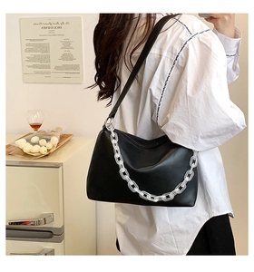 Chic black matte leather shoulder bag with bold acrylic chain and long strap detail