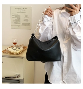 Close-up of black PU leather crescent bag featuring a stylish clear acrylic chain strap