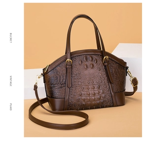 Detail of vintage dark brown crocodile embossed leather handbag with gold metal hardware