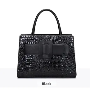 Close-up of black shoulder bag with crocodile texture and large square leather buckle