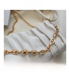 Close-up of ivory pleated leather bag with chunky gold hardware chain strap details