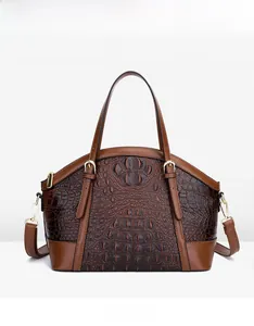 Front view of a dark brown crocodile pattern handbag with golden metal hardware