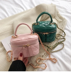 Detail of mini quilted leather chain bags in light pink and dark green colors