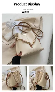 Detailed view of cream bucket bag with silk scarf handle and metal bar accent