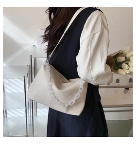 Detail of cream white leather underarm bag with frosted clear chain and pleated texture