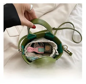 Interior view of green woven crossbody bag with drawstring liner and personal items