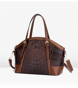 Close-up of brown crocodile texture shell bag with golden hardware and handles