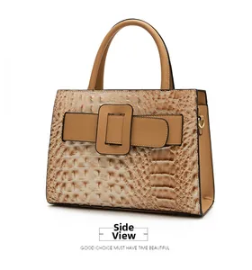 Side view showing the crocodile pattern texture and metal buckle on the khaki handbag