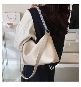Detail of cream PU leather crossbody bag featuring a thick clear acrylic chain strap