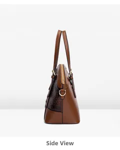 Side view of brown faux leather handbag with crocodile texture and gold hardware details