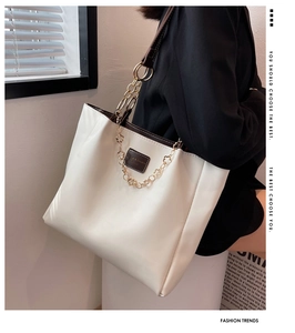 Detail of off-white tote bag with gold petal chain and contrast brown oil edges