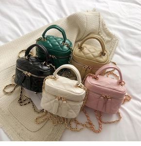 Detailed close-up of five mini quilted vanity bags in diverse colors with chain straps