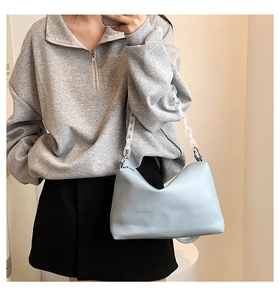Detail of light blue hobo bag with trendy white acrylic chain and soft matte leather texture