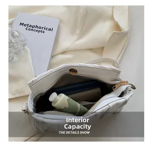 Internal capacity of the white pleated shoulder bag showing space for daily essentials