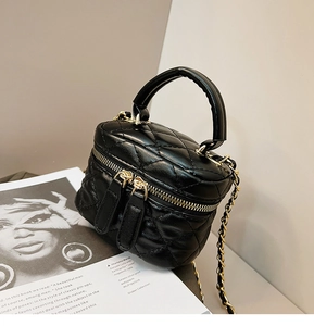 Detail of mini quilted bucket bag with gold chain strap on a fashion magazine
