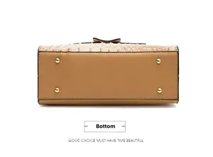 Detail view of khaki handbag bottom featuring crocodile texture and gold protective feet