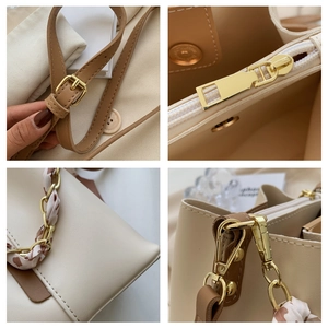 Detail view of the beige chain bucket bag showing high-quality leather texture and hardware