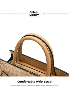 Detail showing the ergonomic handle and crocodile texture of the beige leather shoulder bag