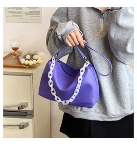 Detail of purple PU leather shoulder bag featuring a chunky white acrylic chain decoration