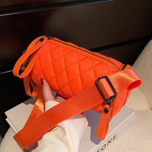 Bright orange quilted nylon cylinder crossbody bag with wide strap and zip closure