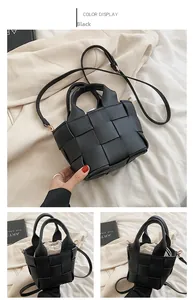 Detail view of black woven handbag showing dual handles and removable shoulder strap