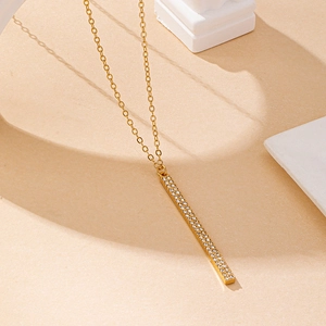 Détail d'un collier pendentif barre géométrique doré avec double rangée de cristaux