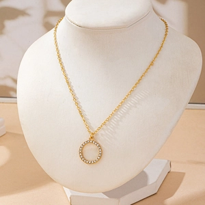 Gros plan du collier pendentif rond doré avec strass scintillants sur un buste d'exposition