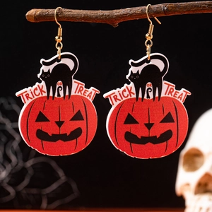 Detail of Halloween pumpkin and black cat earrings with Trick or Treat text on wood