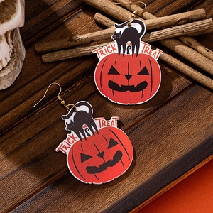 Halloween pumpkin and black cat earrings with Trick or Treat text on wooden background