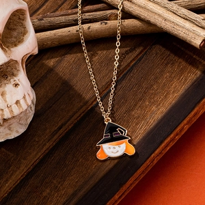 Collier pendentif sorcière d'Halloween avec chaîne dorée sur fond en bois rustique