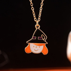 Gros plan d'un collier pendentif sorcière d'Halloween en émail coloré sur chaîne dorée