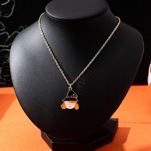 Collier d'Halloween doré avec pendentif sorcière sur un présentoir à bijoux noir