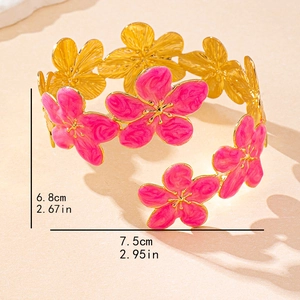Exaggerated golden open bangle featuring five pink enamel flowers with dimension details