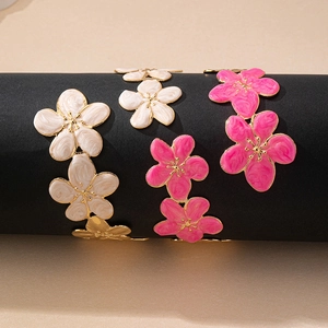 Elegant floral enamel open cuff bracelets in pink and white with golden finish detail