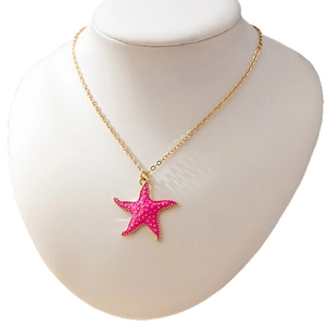 Ocean-inspired gold chain necklace with a pink starfish pendant and dotted texture
