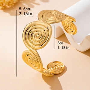 Elegant gold spiral seashell bracelet with matte finish in a minimalist jewelry display