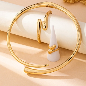 Parure de bijoux dorés minimalistes avec tour de cou, bracelet et bague sur socles géométriques