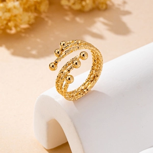 Detailansicht goldener mehrlagiger Spiralring mit Rautenmuster und Kugelenden am Ende