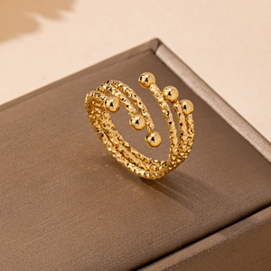 Goldener mehrlagiger Spiralring mit strukturierter Rautenoberfläche und sechs polierten Kugeln