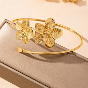 French vintage gold open cuff bracelet featuring 3D textured floral petals on a jewelry box