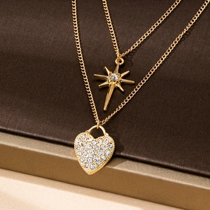 Detail of gold double-layer necklace showing star and heart pendants with white zircons
