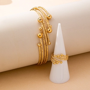 Elegant gold jewelry set featuring a textured cuff bracelet and matching open ring