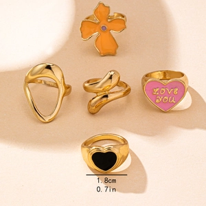 5-piece gold-tone ring set featuring floral and heart designs on a minimalist background