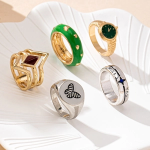 Detail view of five trendy rings featuring a watch-shaped design and miss you engraving