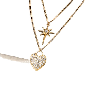 Golden double layer necklace featuring an eight-pointed star and sparkling heart lock charm