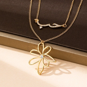 Détail du collier double rang doré avec fleur et pendentif d'amour arabe serti de zircons