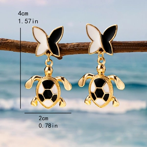 Gold turtle earrings with black and white bow on a beach branch, 4cm drop length