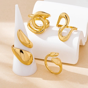 Set of four minimalist gold-plated abstract rings on geometric display props